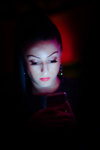 Close-up of woman looking away while illuminated light