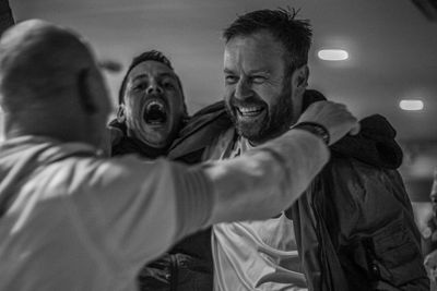 Midsection of man with arms raised outdoors