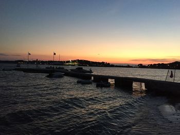 Boats in sea at sunset