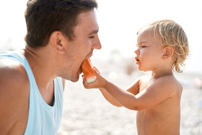 Side view of young couple kissing at beach