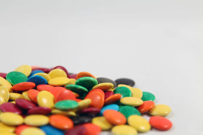 Close-up of multi colored candies against white background