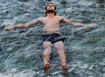 Young man swimming in sea