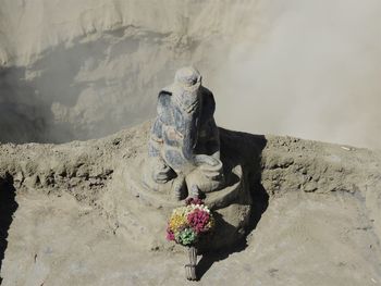 View of buddha statue on rock against sky