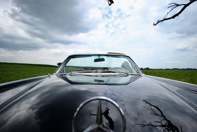 Vintage car on field seen through windshield