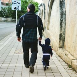 Rear view of men on footpath