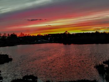 Scenic view of lake against romantic sky at sunset