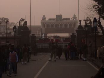 People walking in city against clear sky