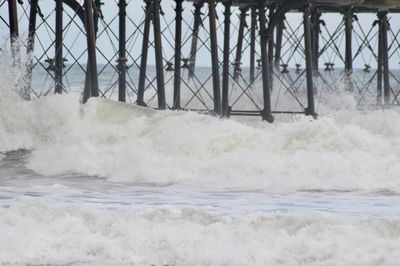 Waves splashing on bridge over sea