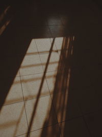 High angle view of shadow on tiled floor