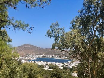 Scenic view of sea and trees against blue sky