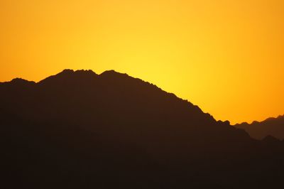 Silhouette mountains against clear sky during sunset