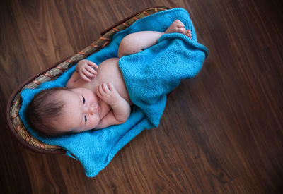 High angle view of baby sleeping on hardwood floor