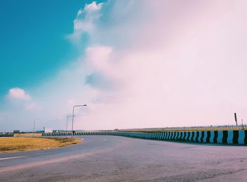 Road by bridge against sky