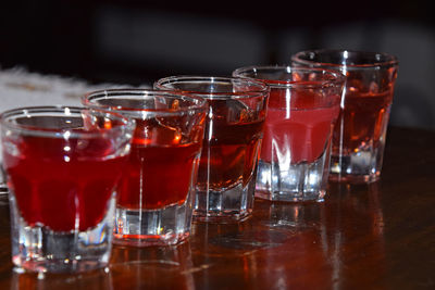 Close-up of alcohol in shot glasses arranged on wooden table