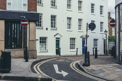 Road sign on street by buildings in city