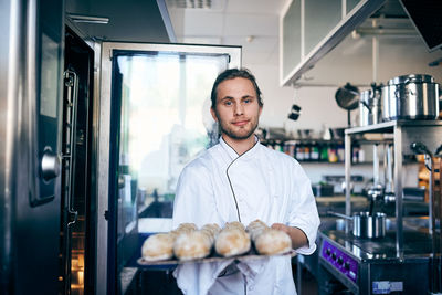 Portrait of young man standing by food