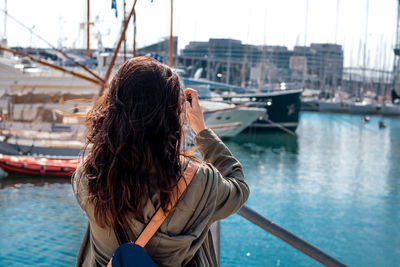 Young woman using mobile phone at harbor