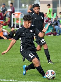 Men playing soccer on field