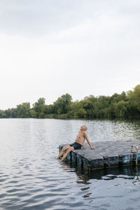 Senior man sitting on raft in a lake