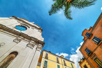 Low angle view of palm trees and buildings against sky