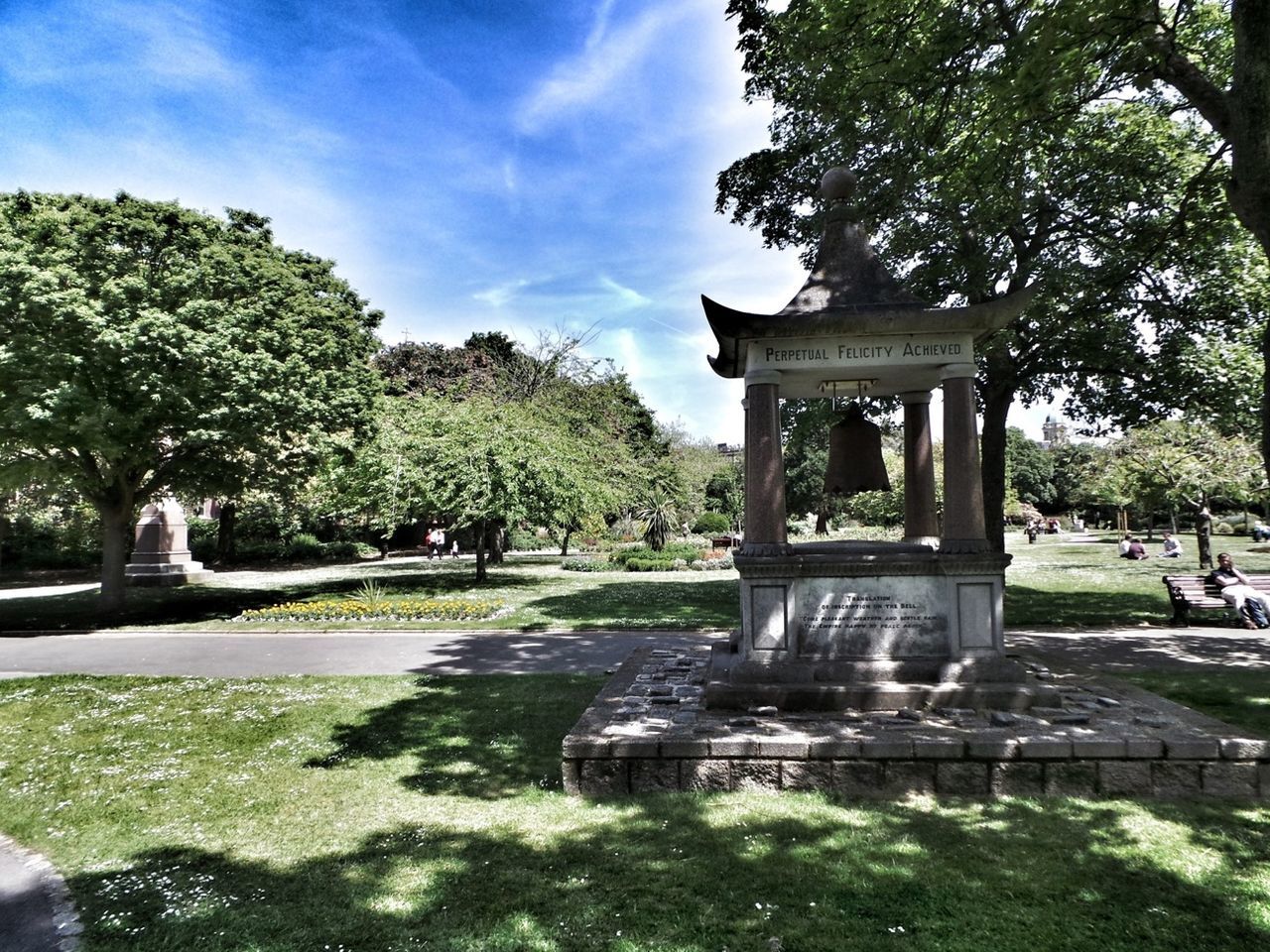 tree, park - man made space, sky, built structure, sunlight, architecture, incidental people, growth, shadow, day, green color, park, travel destinations, nature, tranquility, outdoors, sculpture, architectural column, building exterior, art and craft