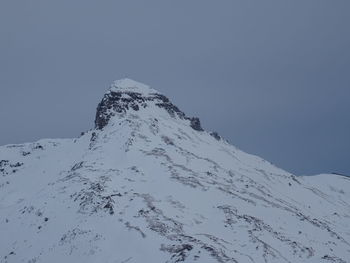 Low angle view of snow covered mountain against clear sky