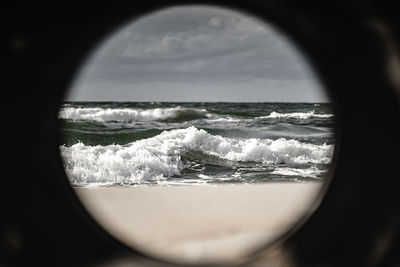 Close-up of sea against sky seen through window