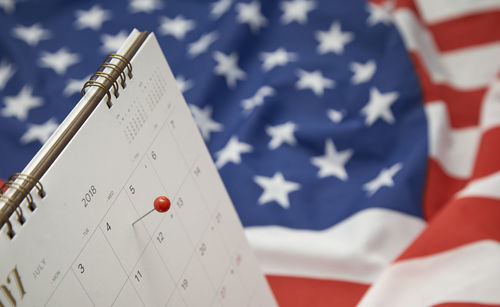 Close-up of thumbtack over calendar marking american national holiday