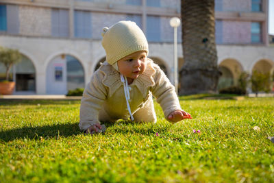 Cute girl crawling on grass at lawn