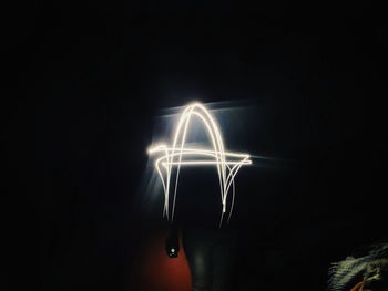 Close-up of illuminated lighting equipment against black background