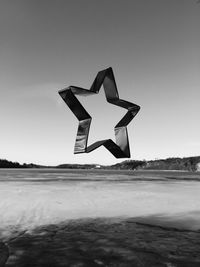 Umbrella flying over beach against clear sky