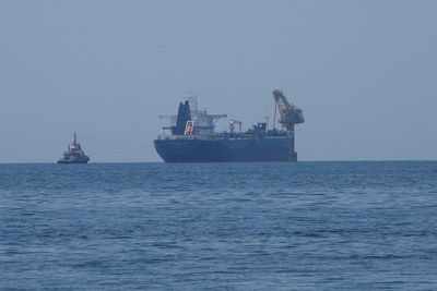 Ship sailing in sea against clear sky