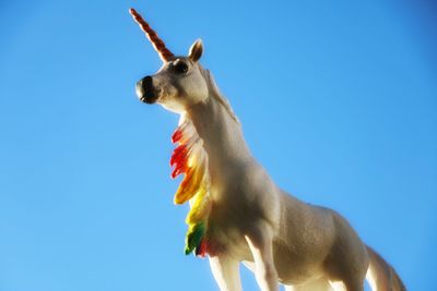 Low angle view of horse against clear blue sky