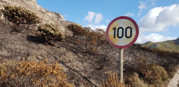 Low angle view of road sign against sky