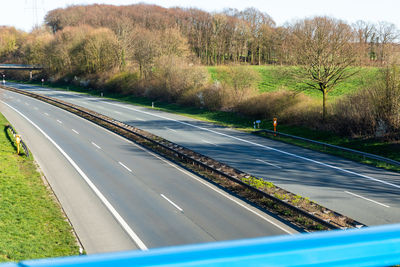 Vehicles on road along trees and plants in city