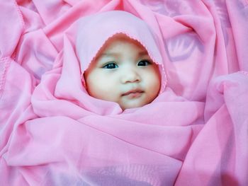 Portrait of cute baby lying on bed