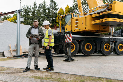 Foreman and customer or client agree about future building work on construction site. man looking in