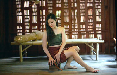 Young woman sitting on chair at home