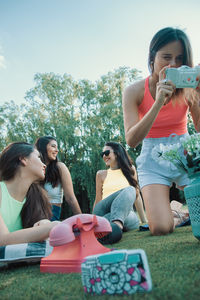 Side view of mother and daughter sitting on field