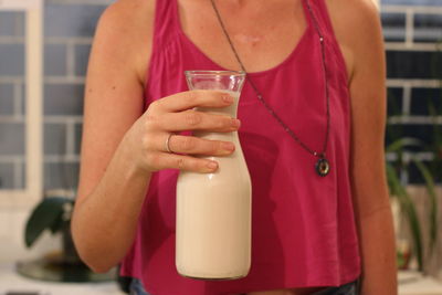 Midsection of woman drinking glass