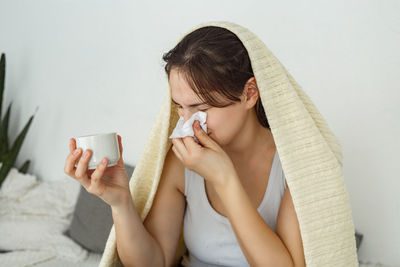 Woman in bed with the flu, sneezing  sick blowing nose