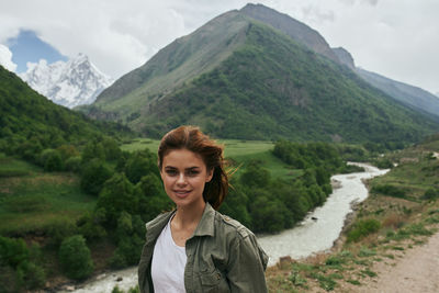 Portrait of young woman standing on mountain