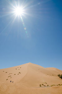 Scenic view of desert against clear blue sky
