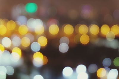 Defocused image of illuminated lights in city at night