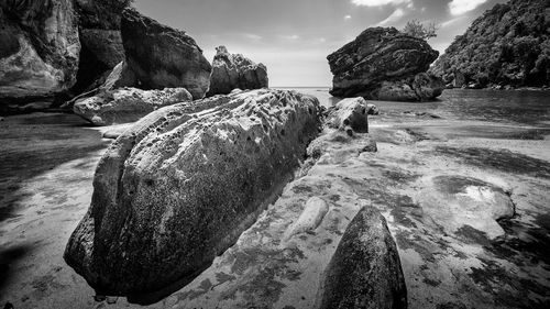 Rock formations by sea against sky