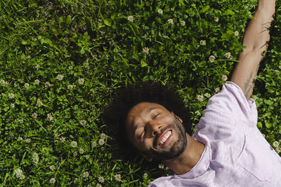 Carefree man lying on grass at park