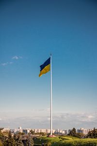 Low angle view of flag against clear blue sky