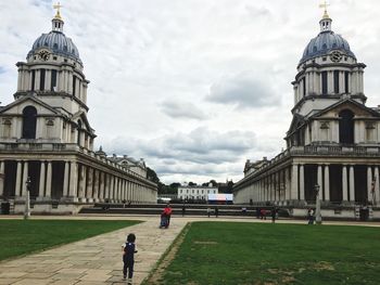 People in front of building against sky