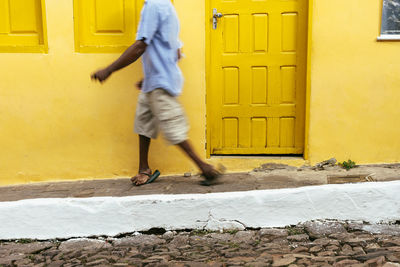 Full length of man walking on yellow door