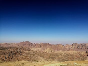 Scenic view of desert against clear blue sky